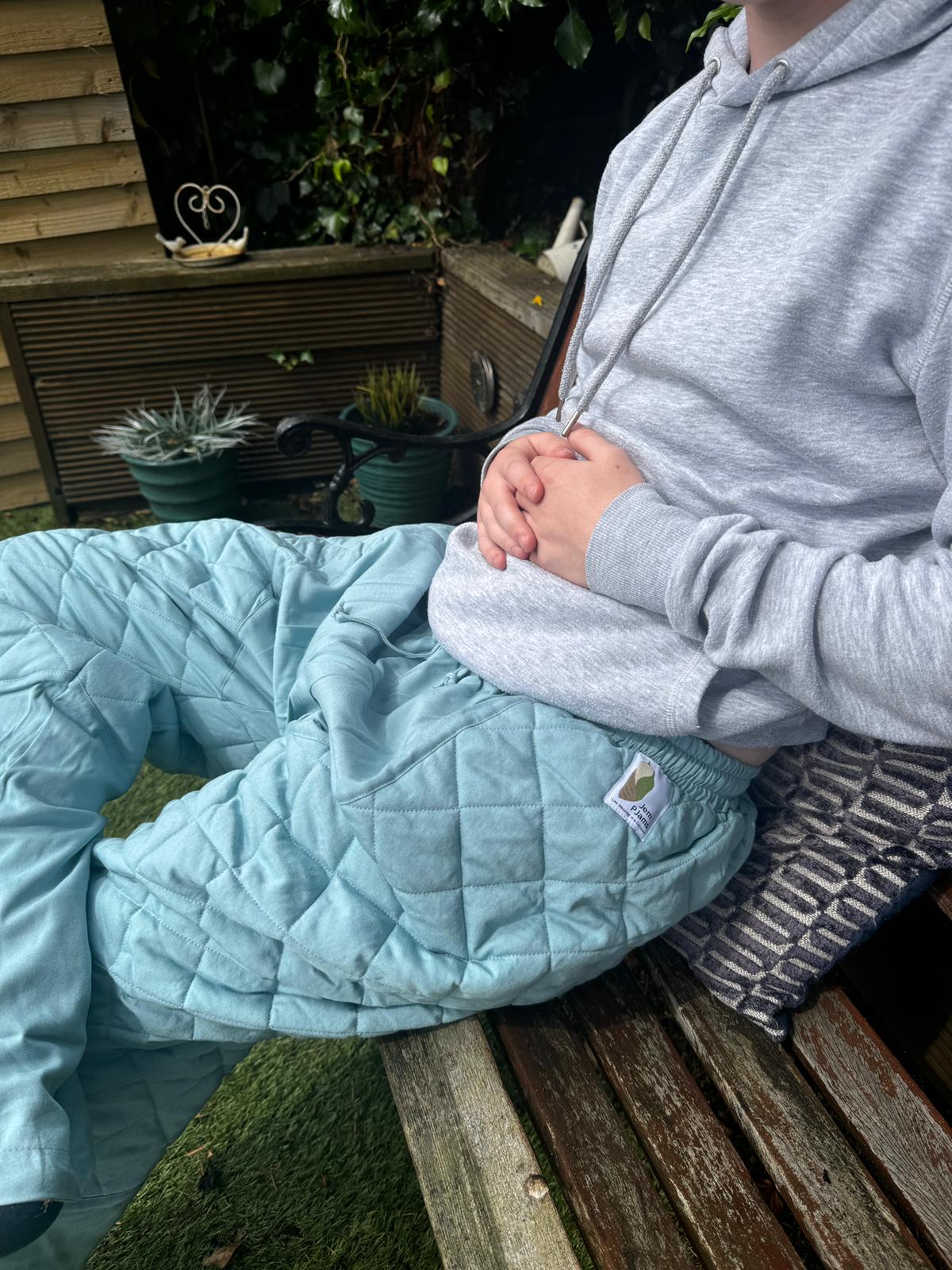 Young man sitting in garden wearing JemPJams Comfort Pyjama Bottoms