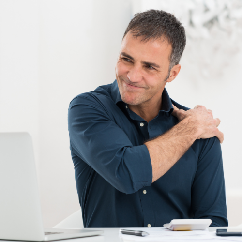 Man in discomfort holding shoulder and experiencing joint pain